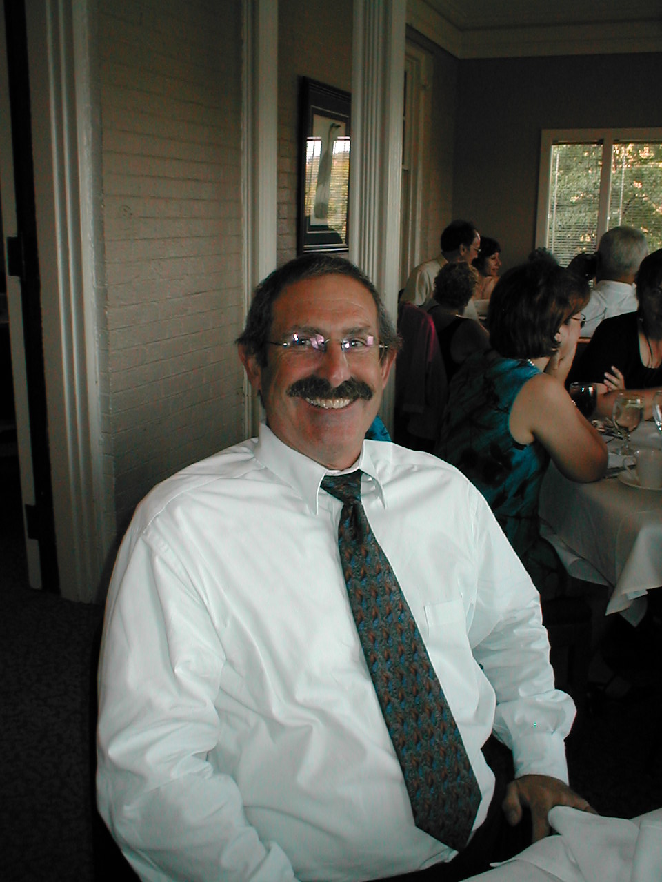 A person wearing a tie and glasses

Description automatically generated