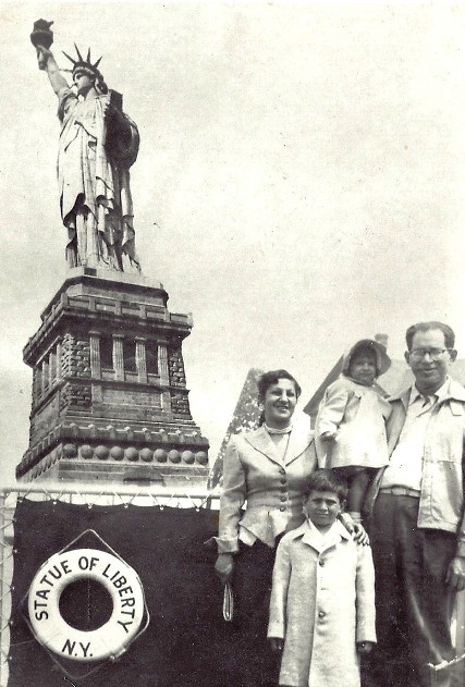 A family posing for a photo in front of a statue

Description automatically generated