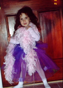 A young child in a pink feathered dress

Description automatically generated