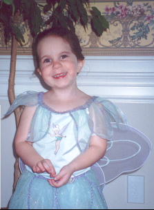 A young child wearing a fairy garment

Description automatically generated