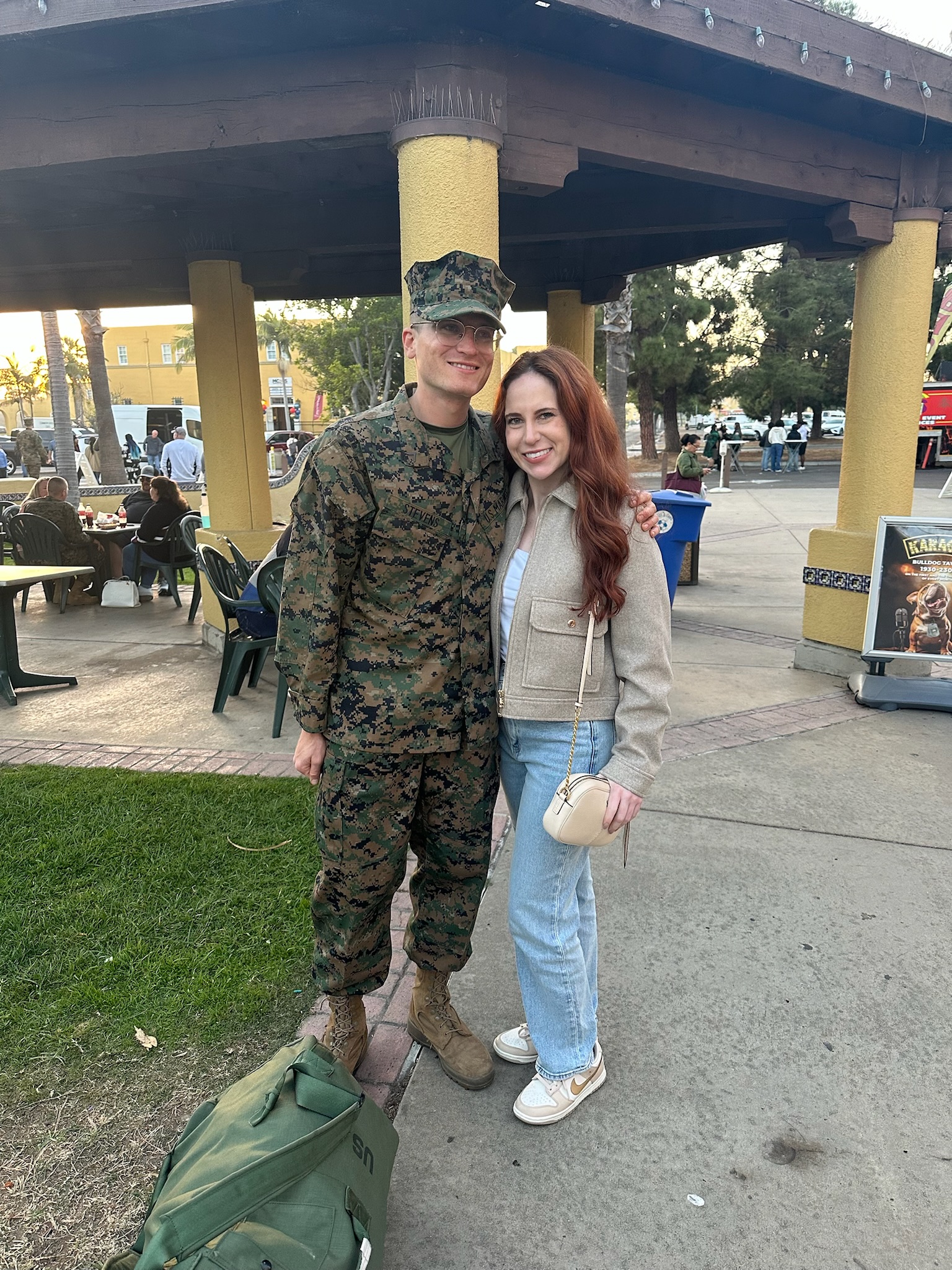 A person in a military uniform standing next to a person

Description automatically generated