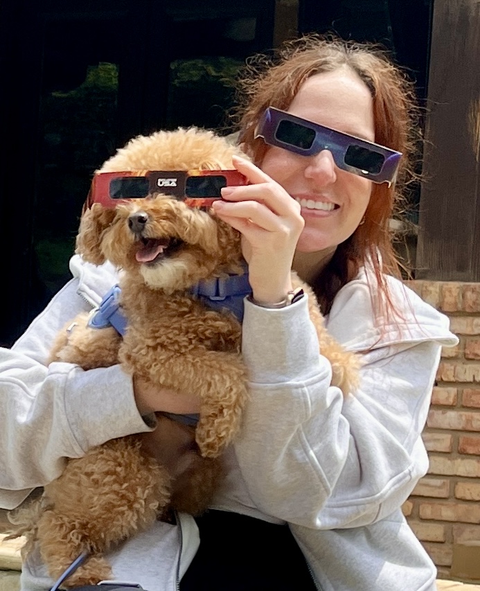 A person holding a dog wearing 3d glasses

Description automatically generated