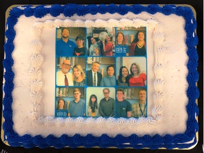 A cake with a group of people on it

Description automatically generated