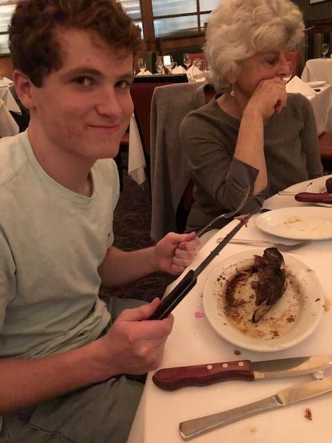 A person and person sitting at a table with food

Description automatically generated