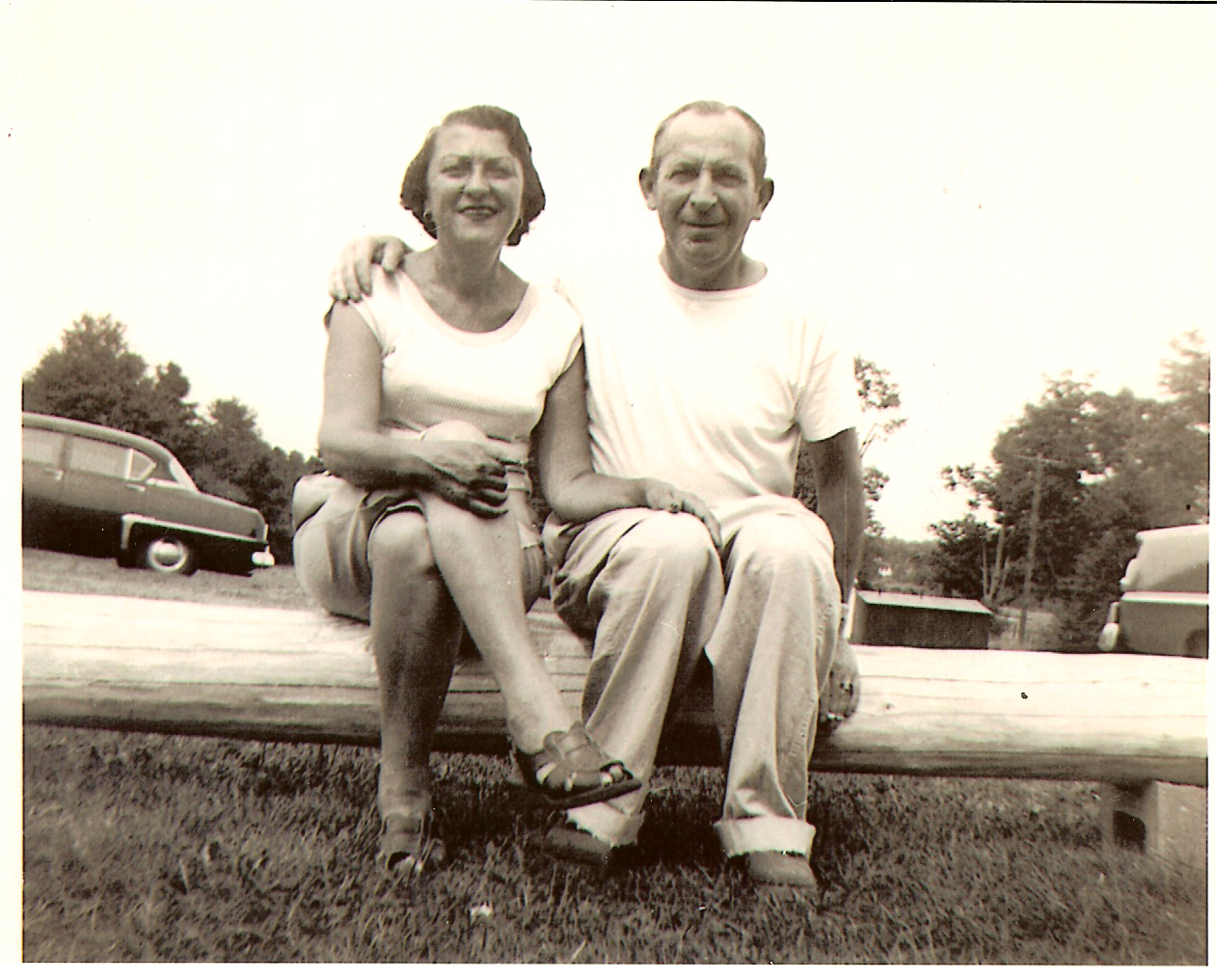 A person and person sitting on a log

Description automatically generated