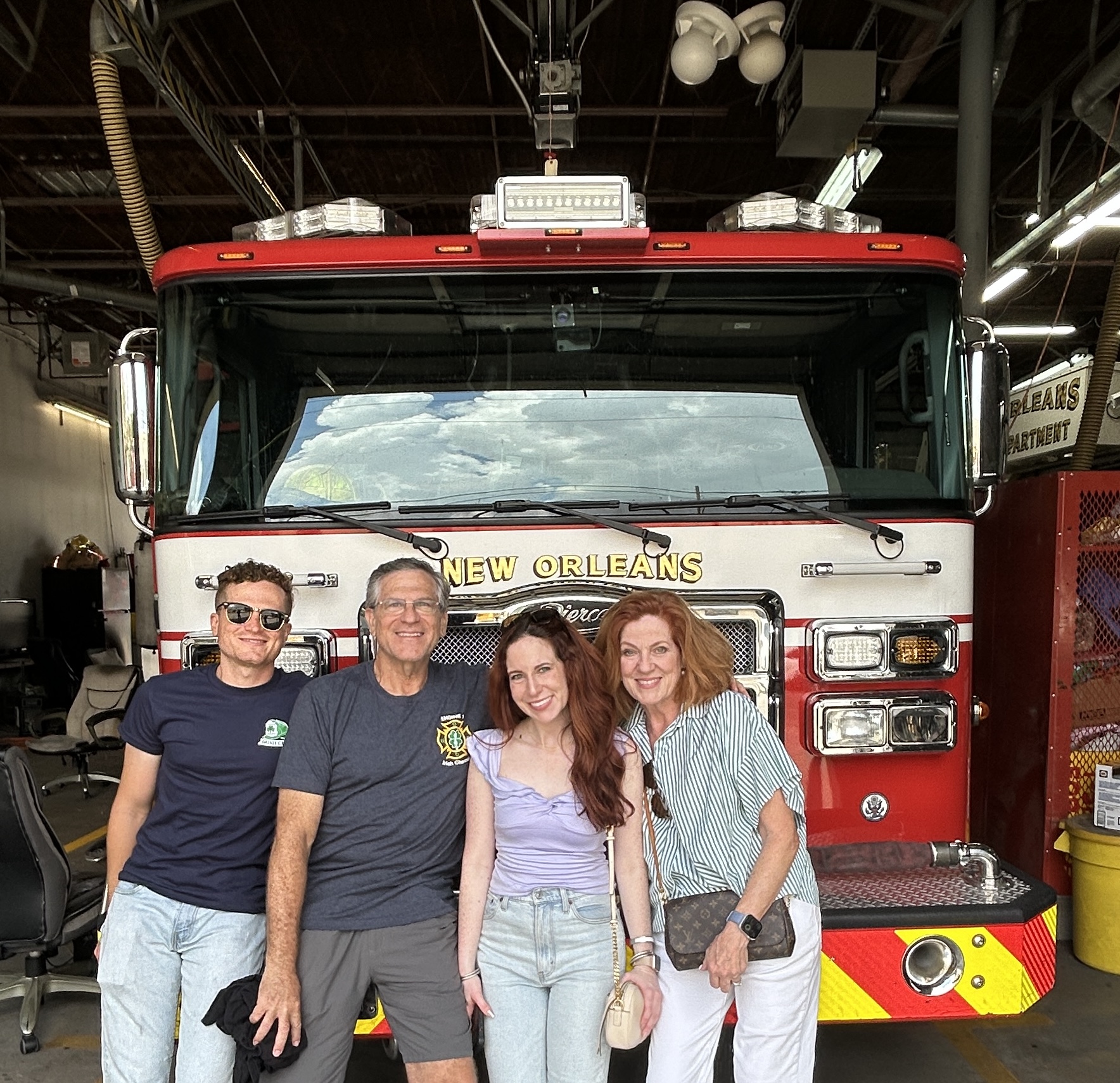 A group of people standing in front of a fire truck
Description automatically generated