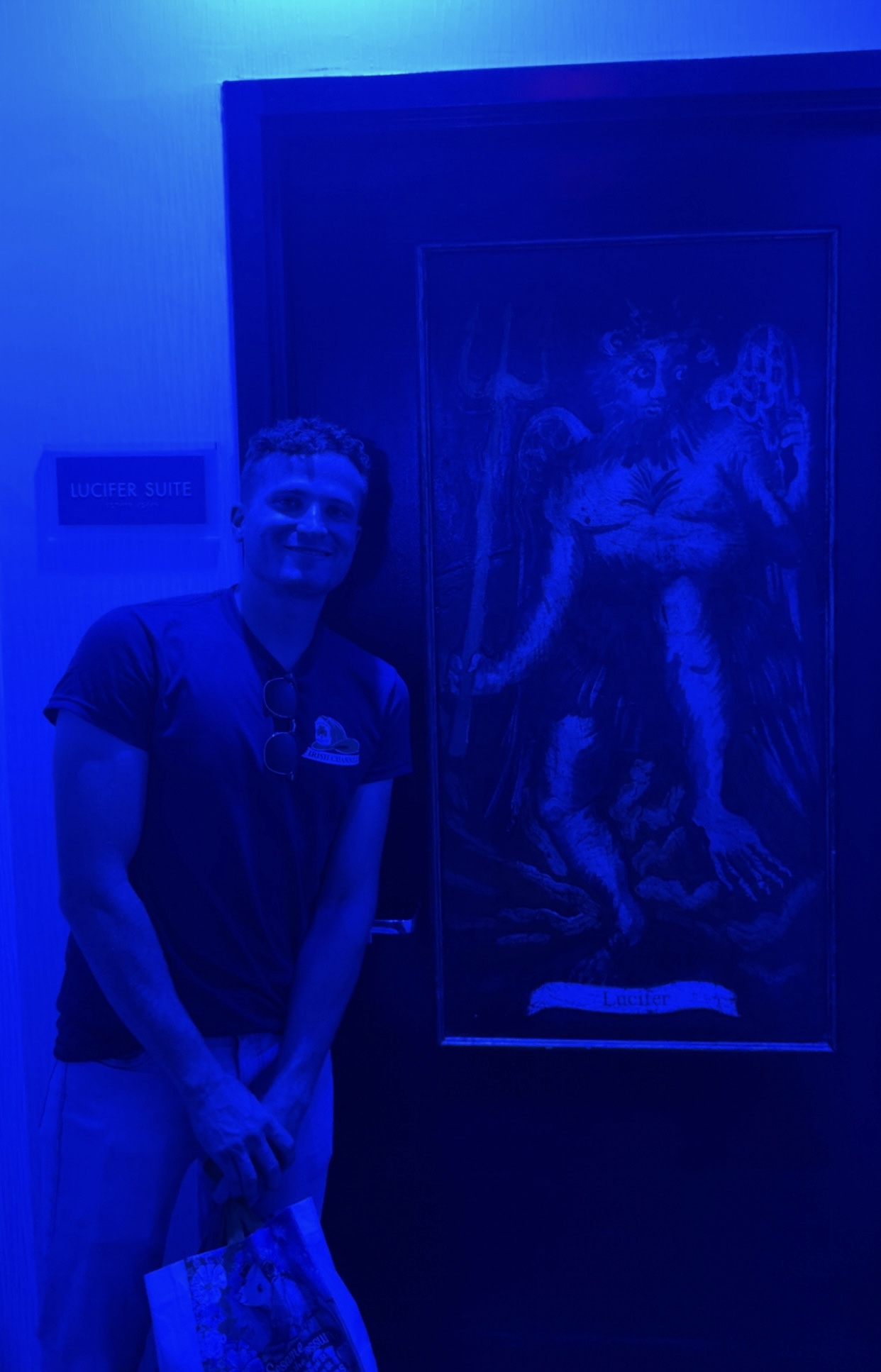 A person standing next to a painting
Description automatically generated