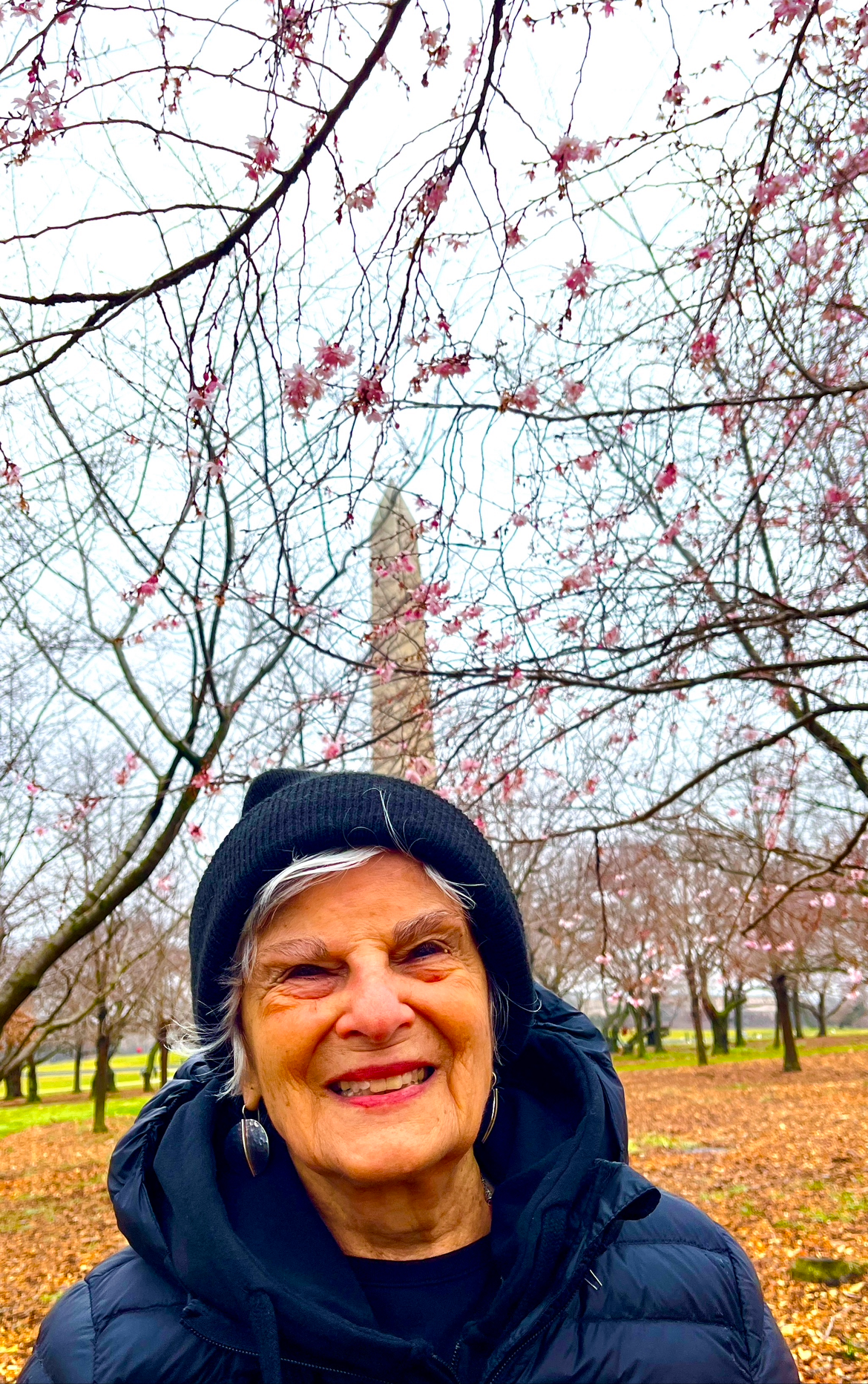 A person smiling in front of a monument

Description automatically generated