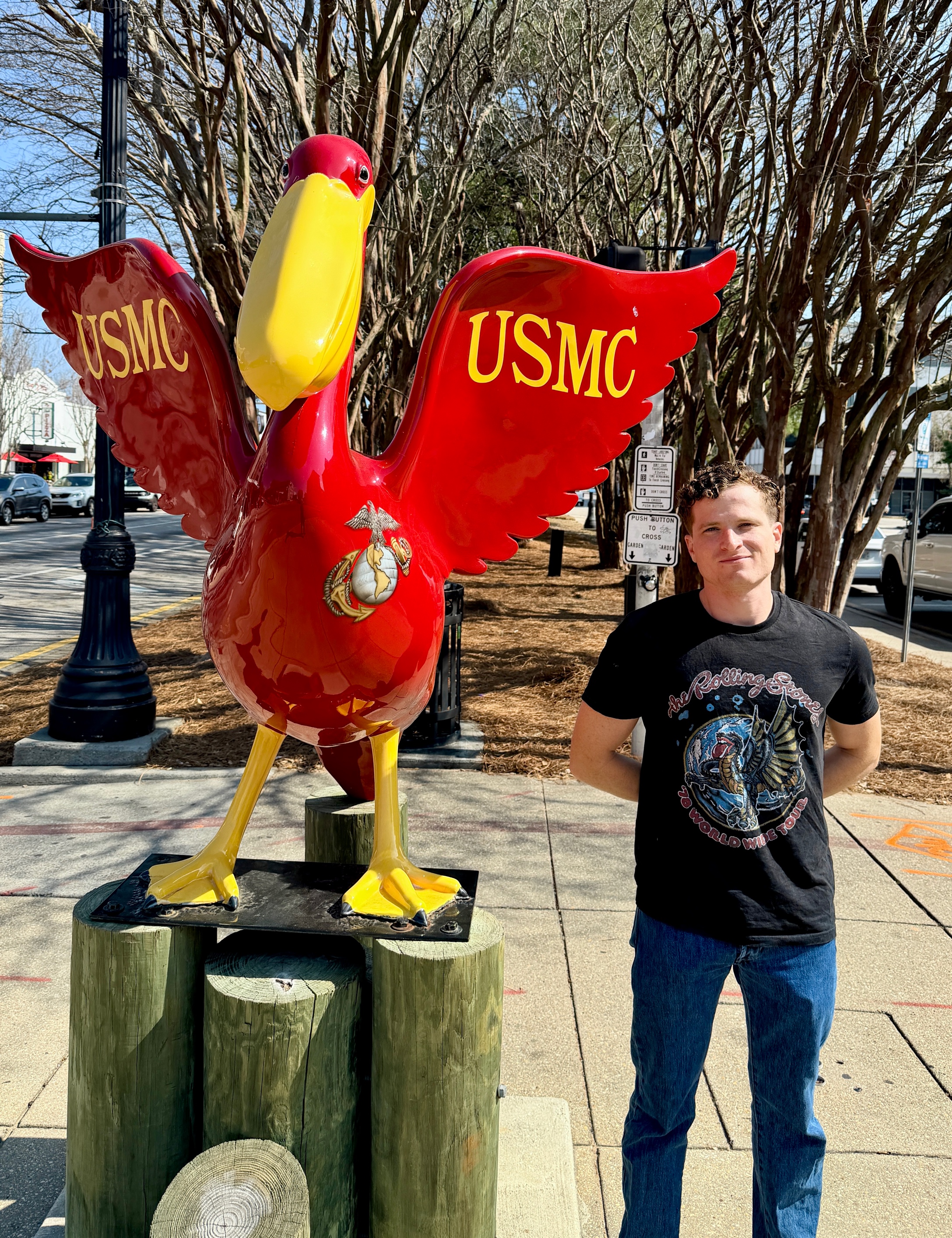 A person standing next to a statue

Description automatically generated