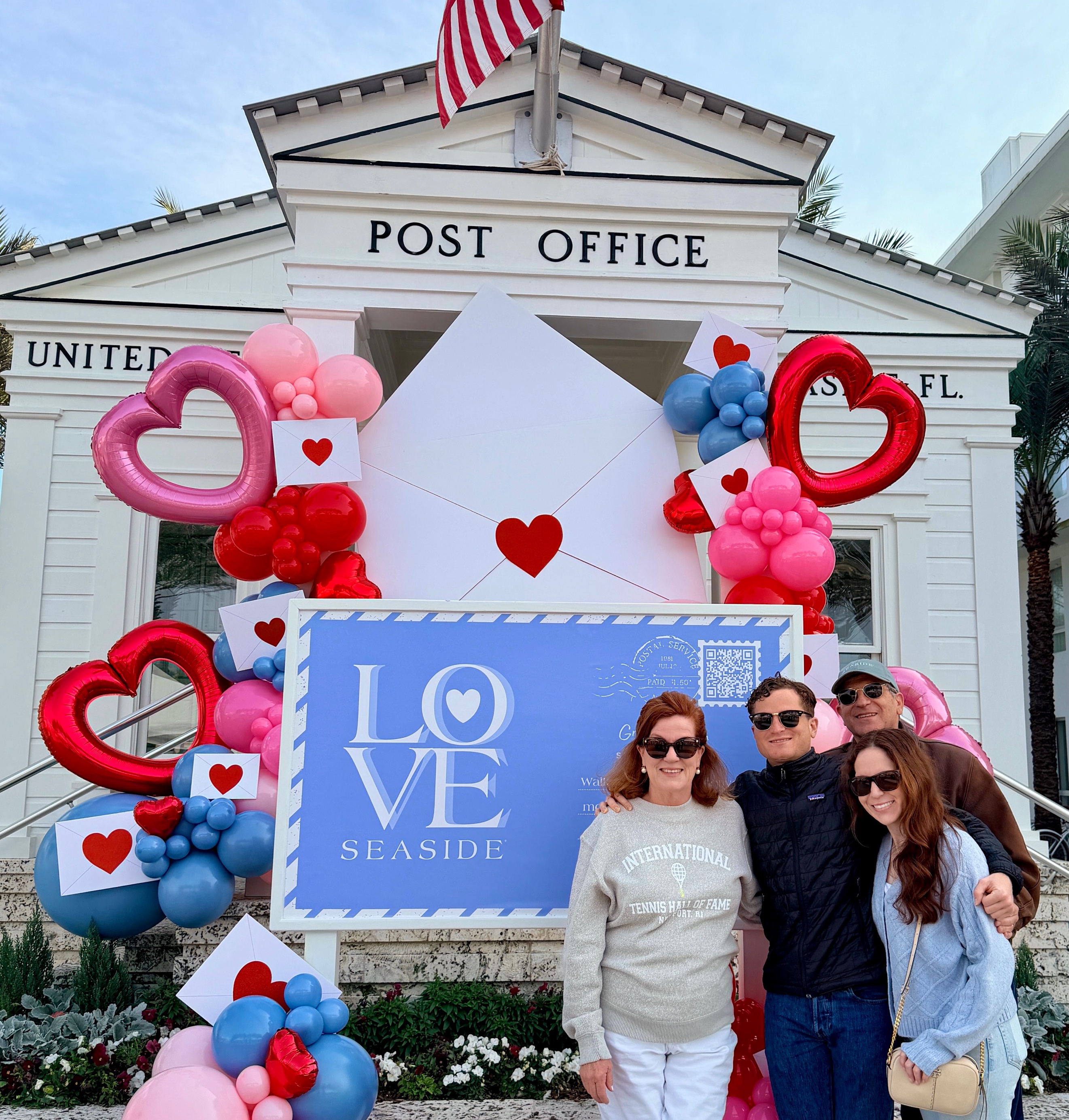 A group of people posing in front of a post office

Description automatically generated