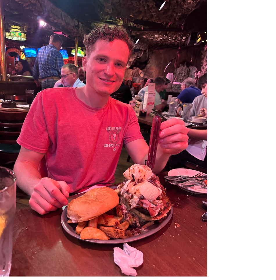 A person sitting at a table with food

Description automatically generated