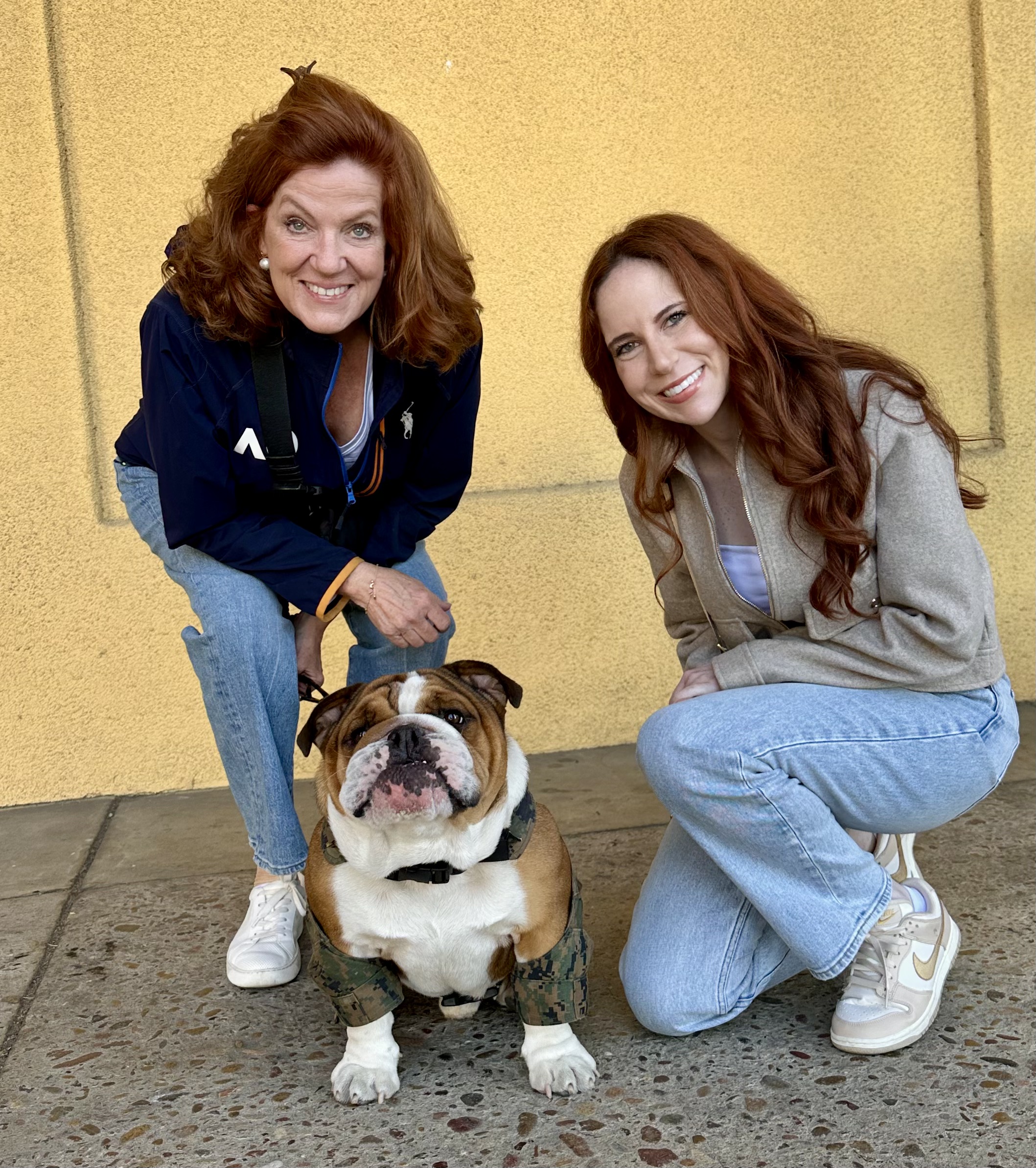 Two women with a dog
Description automatically generated