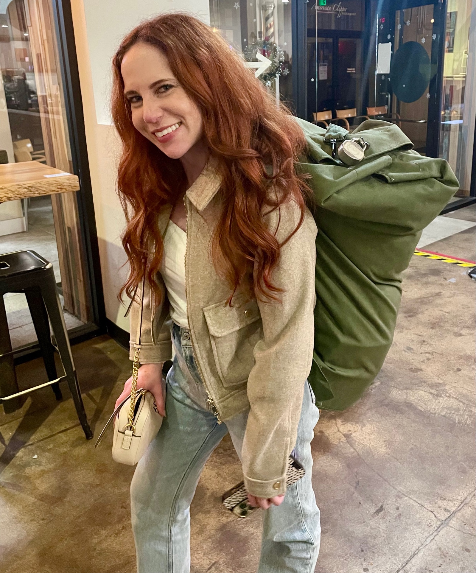 A person with a large green bag on her back
Description automatically generated